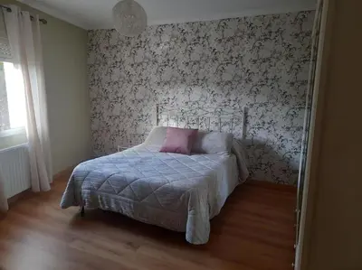 a bedroom with a bed with a pink pillow on it at Casa Daló II in Folgoso