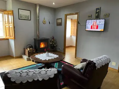 a living room with a table and a fireplace at Refuxio Da Mina in Leborey