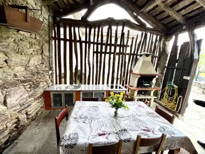 a dining room with a table and a stove at Refuxio Da Mina in Leborey