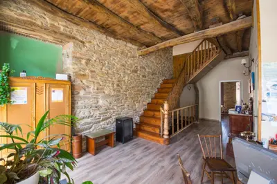 a living room with a staircase and a stone wall at La Casona de Sarria in Sarria