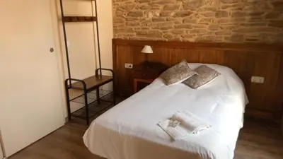 a bedroom with a white bed with two pillows on it at La Casona de Sarria in Sarria