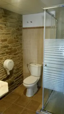 a bathroom with a toilet and a glass shower at La Casona de Sarria in Sarria