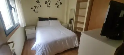 a bedroom with a white bed and a television at Ribeiras do Tamega in Verín