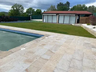 a backyard with a swimming pool and a house at Casa do alpendre in Ourense
