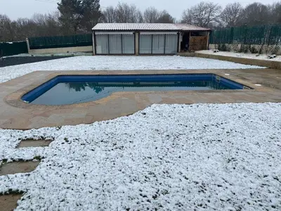 a swimming pool covered in snow next to a house at Casa do alpendre in Ourense