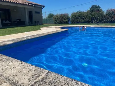 a person swimming in a blue swimming pool at Casa do alpendre in Ourense
