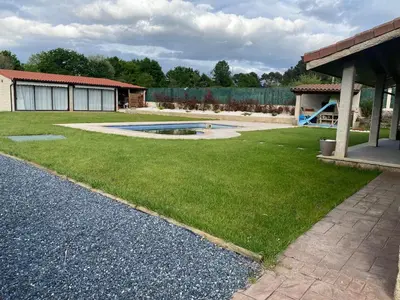 a yard with a swimming pool and a building at Casa do alpendre in Ourense