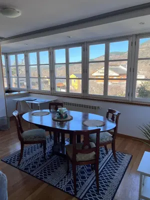 a dining room with tables and chairs and windows at Casa la Plaza in Molinaseca