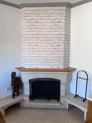 a living room with a white brick fireplace at Casa la Plaza in Molinaseca
