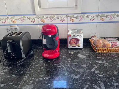 a kitchen counter with a toaster and a toaster and bread at Casa la Plaza in Molinaseca