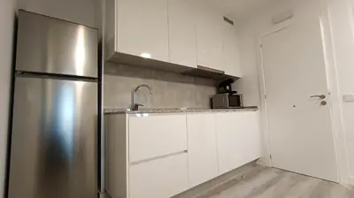 a kitchen with a stainless steel refrigerator and white cabinets at Casa Rectoral de Rante in Rante