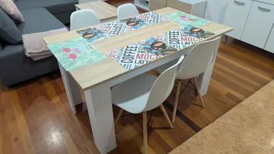 a dining room table with two chairs and a table with a magazine on it at Alojamiento La Caridad in La Caridad