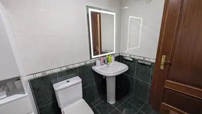 a bathroom with a sink and a toilet and a mirror at Alojamiento La Caridad in La Caridad