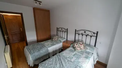 two twin beds in a room with a door at Alojamiento La Caridad in La Caridad