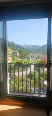 a window view of a balcony with pink flowers at Alojamiento Turístico Santalla in Santa Eulalia de Oscos