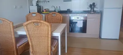 a kitchen with a table with three chairs and a stove at Alojamiento Turístico Santalla in Santa Eulalia de Oscos