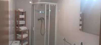 a bathroom with a shower with a glass door at Alojamiento Turístico Santalla in Santa Eulalia de Oscos