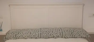 a bed with a black and white pillow on it at Alojamiento Turístico Santalla in Santa Eulalia de Oscos