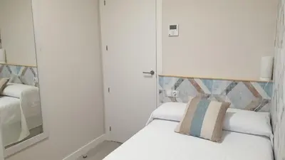 a bedroom with a white bed and a mirror at Abacería in Allariz
