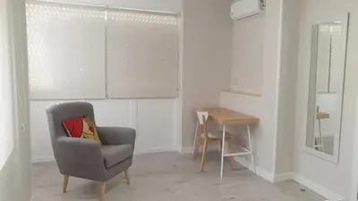 a living room with a chair and a table at Abacería in Allariz
