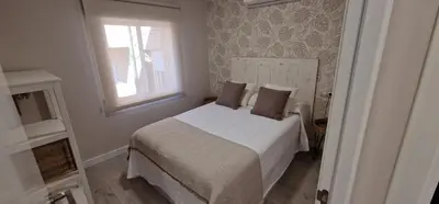 a bedroom with a white bed and a window at Abacería in Allariz