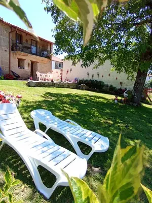 two white lawn chairs sitting in the grass at A Feitiña de Rubiacós in Rubiacós