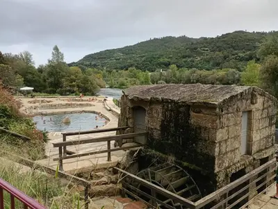 a stone building next to a body of water at A Feitiña de Rubiacós in Rubiacós