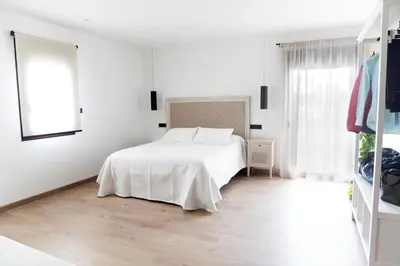 a white bedroom with a white bed and a window at La Molinera Casa Rural - Ribeira Sacra in Ourense