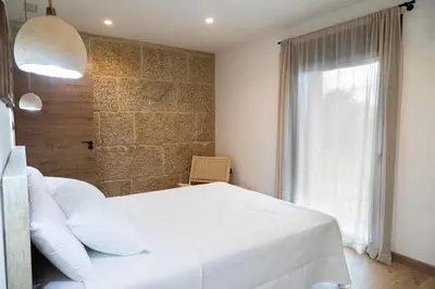 a bedroom with a white bed and a window at La Molinera Casa Rural - Ribeira Sacra in Ourense