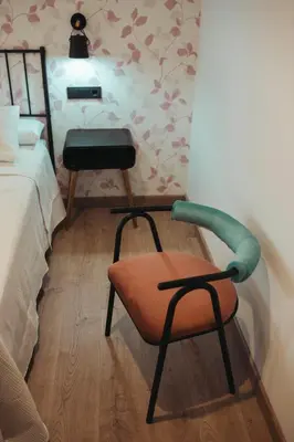 a bedroom with a chair next to a bed at La Molinera Casa Rural - Ribeira Sacra in Ourense