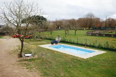 a small swimming pool in a field with a tree at La Molinera Casa Rural - Ribeira Sacra in Ourense