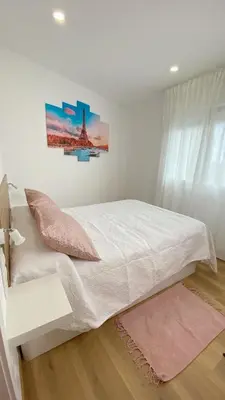 a bedroom with a white bed and a painting on the wall at Gallaecia Dúplex in Arzúa