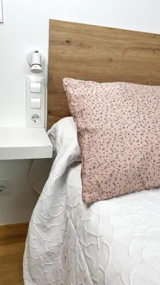 a white bed with a wooden headboard and a pillow at Gallaecia Dúplex in Arzúa