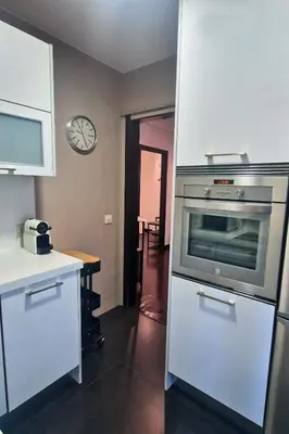 a kitchen with an oven and a table and a clock at YourHouse Ourense Bello 1 Loft in Ourense