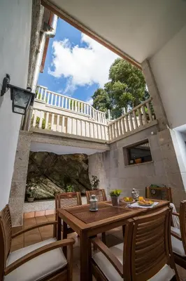 a dining room with a wooden table and chairs at Casa Juancito in Santiago de Compostela