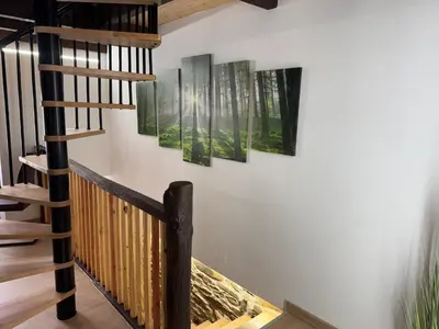 a staircase in a house with three paintings on the wall at Casa Lounge Xacobeo in Tríacastela