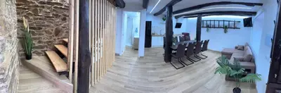 a living room with chairs and a stone wall at Casa Lounge Xacobeo in Tríacastela