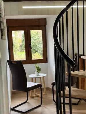 a black chair sitting next to a staircase with a window at Casa Lounge Xacobeo in Tríacastela