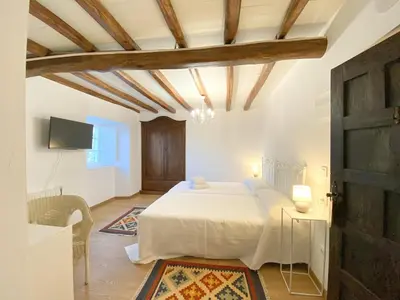 a bedroom with a white bed and a tv at Casa Pastur in Serantes