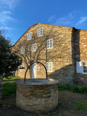 a stone building with a round window in front of it at Casa Pastur in Serantes