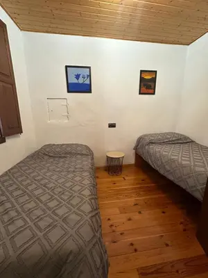 a bedroom with two beds and a wooden floor at Casa Rural Melon in Melón