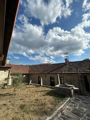 an old house with a blue sky and clouds at Casa Rural Melon in Melón