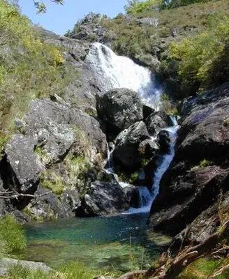 a waterfall on the side of a mountain next to a river at Casa Rural Melon in Melón