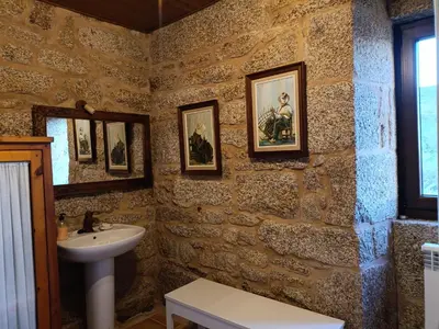 a bathroom with a sink and some pictures on the walls at O Campo DaFolla in Caroy