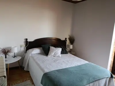 a bedroom with a bed with a green and white blanket at O Campo DaFolla in Caroy