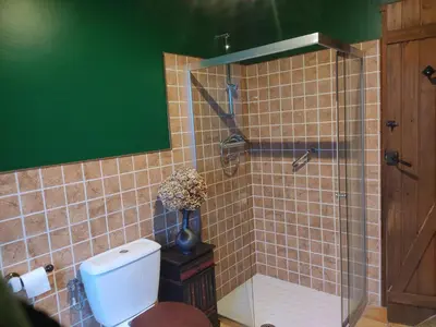 a bathroom with a toilet and a glass shower at O Campo DaFolla in Caroy