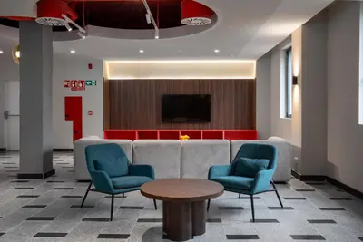 a lobby with a couch and chairs and a tv at Lemonade Stays Santiago de Compostela in Santiago de Compostela