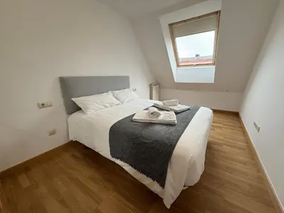 a bedroom with a large white bed with a window at Oktheway O Burgo in El Burgo