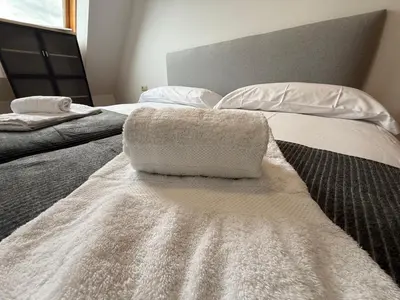 a bed with a white blanket on top of it at Oktheway O Burgo in El Burgo