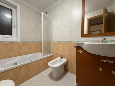 a bathroom with a sink and a toilet and a mirror at Oktheway O Burgo in El Burgo
